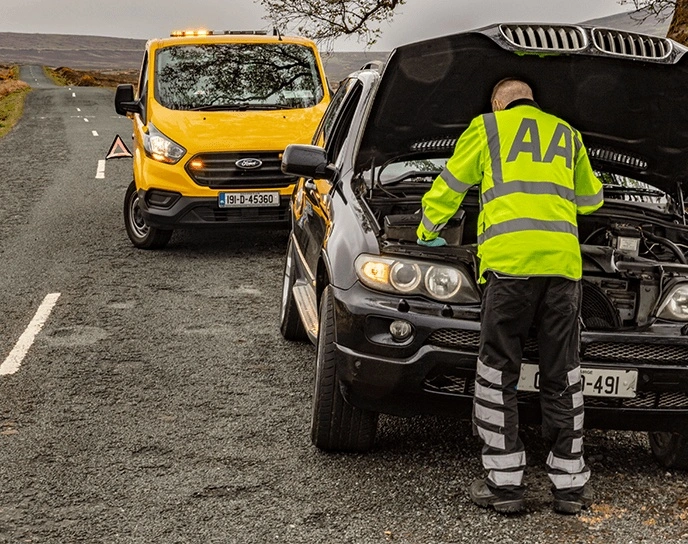 AA Patrol looking at a car engine with an AA rescue van in the distance, Breakdown Assistance, Roadside Assistance,